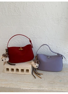 Detail of retro matte handbags in red and purple with gold clasp and leopard charm