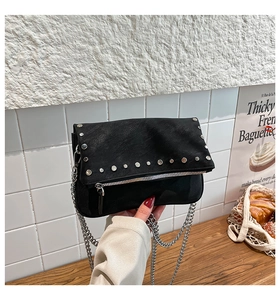Detail of black PU leather crossbody bag with silver studs and chain strap