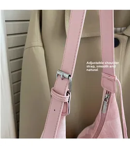 Close-up of pink textured tote bag showing adjustable metal buckle strap and silver zipper