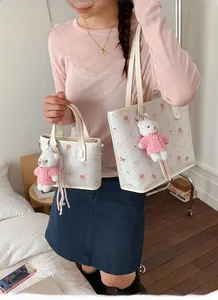 Detail of cute bear printed tote bag with textured surface and plush charm in home setting
