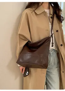 Detail of dark brown matte leather shoulder bag with knotted strap and large capacity