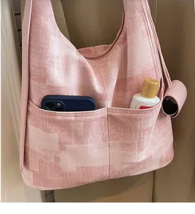 Close-up of pink geometric tote bag showing two front pockets for phone and bottle storage