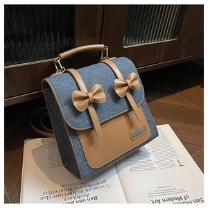 Detail of vintage denim backpack with brown leather trim and cute bow decorations