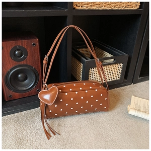 Detail of polka dot cylinder shoulder bag with heart pendant and adjustable strap