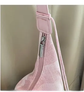 Detailed close-up of smooth silver metal zipper and stitching on a pink tote bag