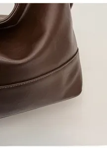 Close-up of the reinforced leather edges and precise stitching on the retro shoulder bag