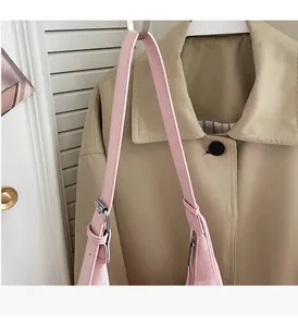 Detailed shot of pink crossbody bag with adjustable leather strap and silver buckle