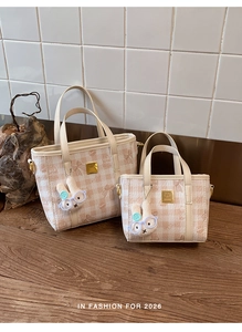 Detail of pink plaid bucket bag set with bear patterns and plush bunny charms
