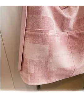 Detail of pink woven texture on large tote bag with smooth faux leather shoulder strap