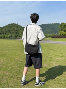 Outdoor view of a black nylon crossbody bag with adjustable strap in a scenic landscape