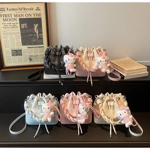 Close-up of small drawstring bucket bags with woven handles and cute plush charms