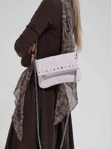 Chic pink leather crossbody bag with silver studs and chain strap shown on model