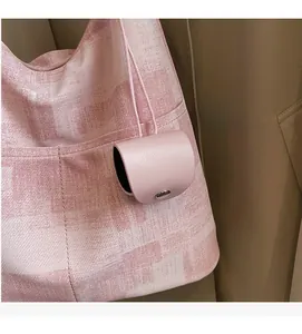 Pink leather mini coin purse charm with silver snap button on a checkered tote bag