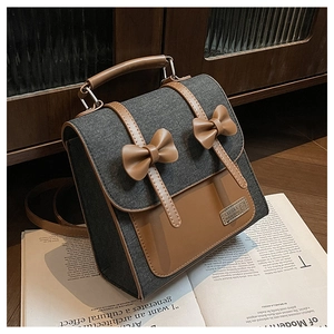 Detail of denim and leather patchwork backpack with brown bow ties and metal hardware