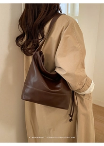 Detail view of large dark brown hobo shoulder bag showing leather texture and woven cord