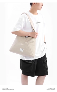 Dettaglio della borsa tote in tela beige con tasca laterale ed etichetta Keep Going