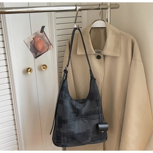 Detailed shot of a large Hobo bag with black abstract pattern and leather shoulder strap