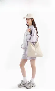 Vista dettagliata della borsa tote beige capiente con etichetta e tracolla larga