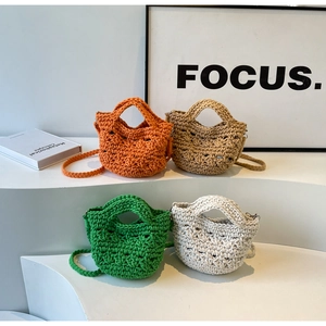 Detail view of four crochet knit mini bucket bags in orange, khaki, green, and beige