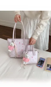 Detail of pink cartoon bear tote bag set with plush charms and textured PU leather