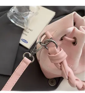 Macro detail of pink drawstring bucket bag with jacquard pattern and silver hardware