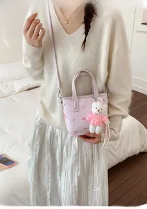 Detail of light purple mini tote with cute bow print and plush bear pendant accessory