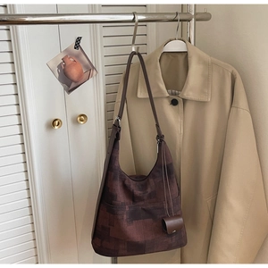 Detail of vintage pattern tote bag with round coin purse hanging on a metal rack