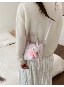 Pink mini tote bag with adjustable strap and cute white bear plush pendant detail