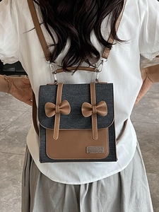Sac à dos en denim gris avec nœuds en cuir marron et bretelles de style collège