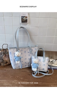 Close-up of cute blue cat print tote bag set with plush bear charm and matching small pouch