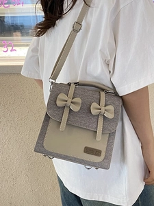 Preppy style beige and grey two-tone backpack with bow accents and adjustable straps