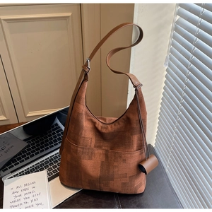 Detail view of caramel hobo bag with geometric texture and leather strap decoration