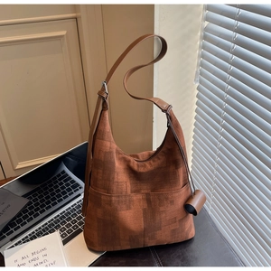 Brown vintage tote bag with pixel pattern next to a laptop in a lifestyle setting