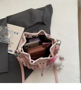 Inside view of pink bucket bag showing phone and wallet storage with rabbit charm