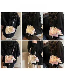 Fashionable bucket bag with drawstring closure and star embroidery shown on models