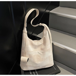Close-up of beige canvas hobo bag with abstract pattern and silver metal buckle