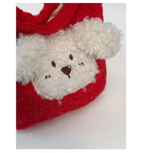 Close-up of red plush bucket bag with white puppy face detail and zipper closure