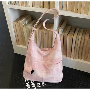 Detailed view of pink plaid tote bag featuring front dual pockets and leather shoulder strap