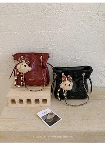 Detail of quilted bucket bags with gold chain straps and cute plush bear accessories