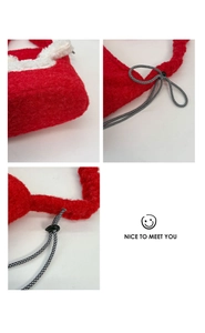 Detail of red plush bucket bag showing soft shearling texture and woven drawstring