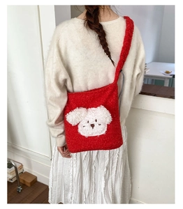 Detail of red plush puppy bucket bag showing soft teddy faux fur texture and 3D dog embroidery