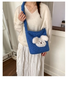 Blue plush puppy bucket bag on model with braided shoulder strap detail