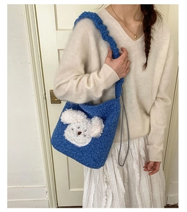 Detailed close-up of blue teddy plush bucket bag featuring cute white puppy embroidery