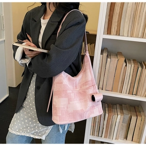 Pink geometric pattern shoulder bag with a mini cylindrical purse and wide strap