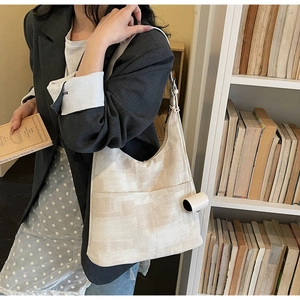 Close-up of beige geometric texture hobo bag with functional side pocket detail