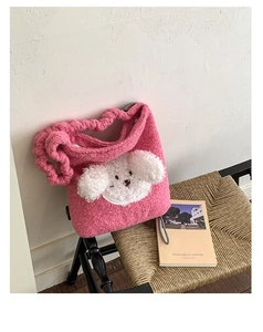 Detailed view of pink plush bucket bag with cute white puppy patch and woven strap