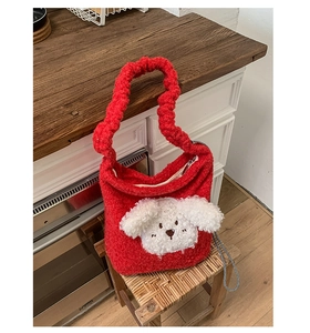 Close-up of red plush bucket bag featuring a 3D white puppy head and soft fleece texture