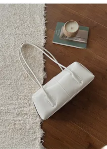 Dettaglio della borsa sottobraccio bianco crema con doppie tracolle e cuciture