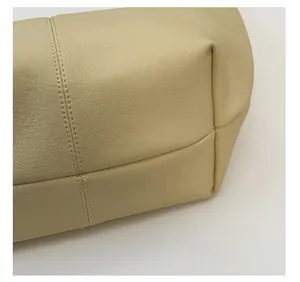 Detail of beige faux leather bag base showing premium pebbled texture and reinforced stitching