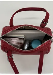 Top-down view of the red cylinder handbag showing spacious interior and items